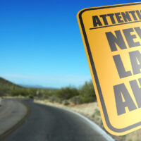 attention new law ahead road sign with skyp background and desert road