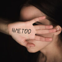 Girl covers her face with hand with hashtag metoo against harassment Girl covers her face with hand with hashtag metoo against harassment