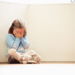 child abuse concept shown with Unhappy Child Sitting On Floor In Corner At Home child abuse concept shown with Unhappy Child Sitting On Floor In Corner At Home