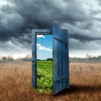 Creative background. Old wooden door, blue color, in the box. Transition to a different climate. The concept of climate change, portal, magic. Copy space.