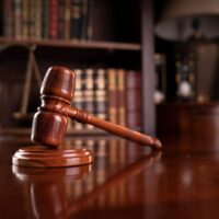 Law theme. Lawyers office. Gavel and scale on the brown desk. Bookshelf with legal books. Law theme. Lawyers office. Gavel and scale on the brown desk. Bookshelf with legal books.