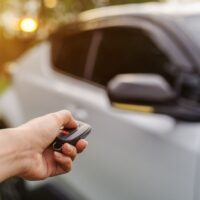 hand using remote key to unlocked car hand using remote key to unlocked a car