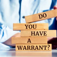 close-up-on-businessman-holding-a-wooden-block-with-do-you-have-a-warrant-message